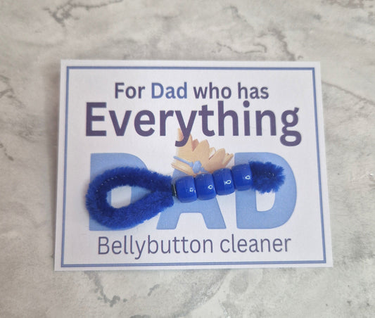 Blue bellybutton cleaner with a humorous label on a marble surface